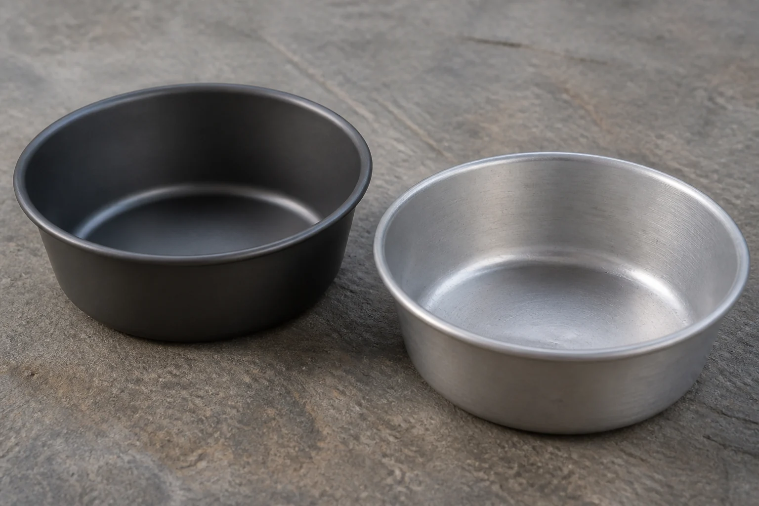 Matte anodized aluminum bowl beside a plain aluminum bowl for surface comparison
