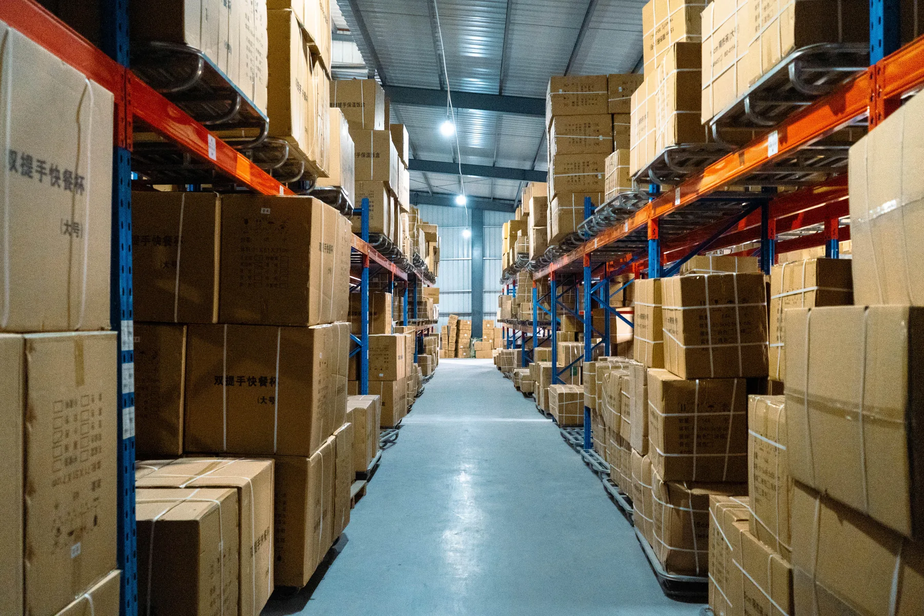 Naike finished-goods warehouse aisle with export cartons on storage racks