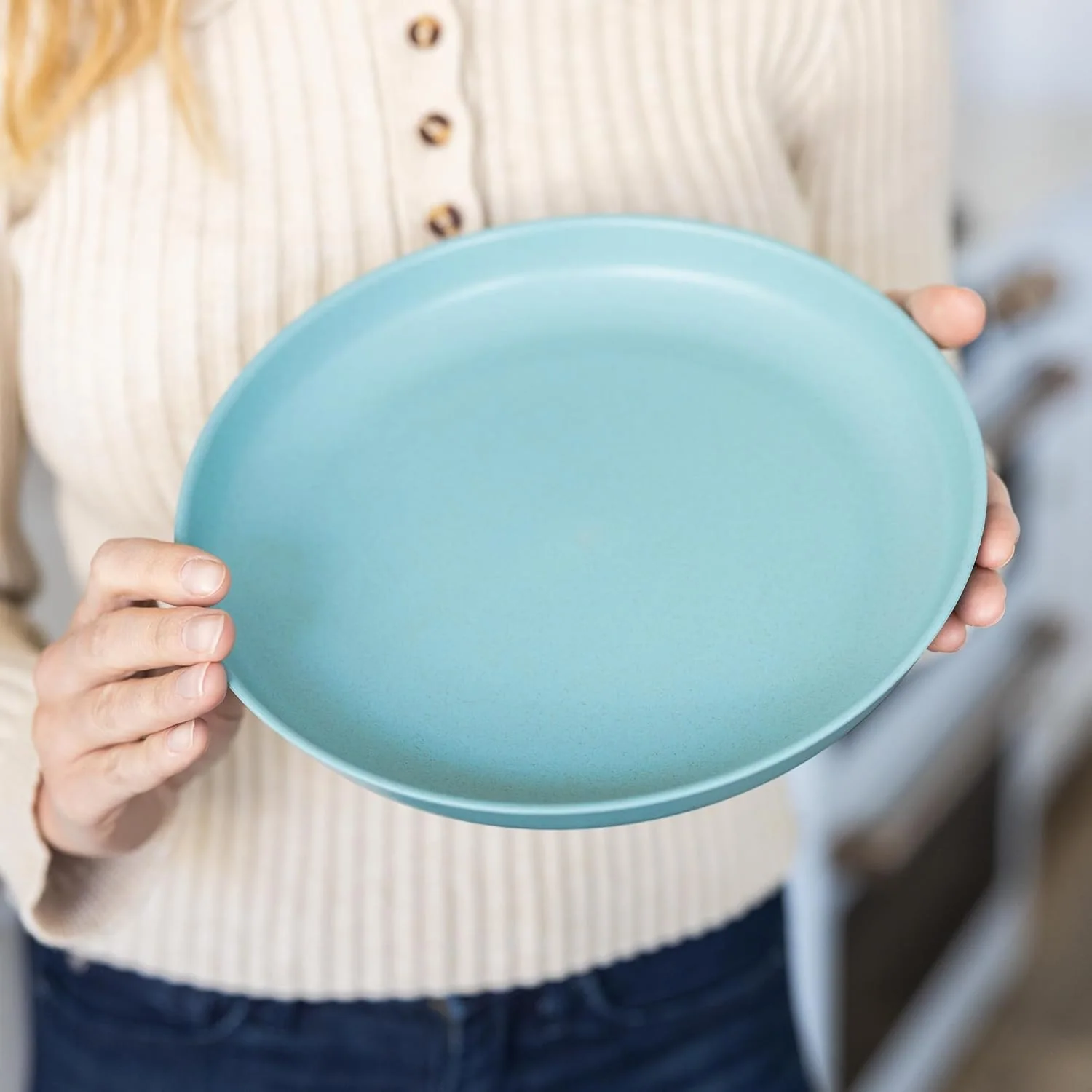 Light blue plate rim and surface detail Close view of a round light blue plate held upright to show rim and surface finish