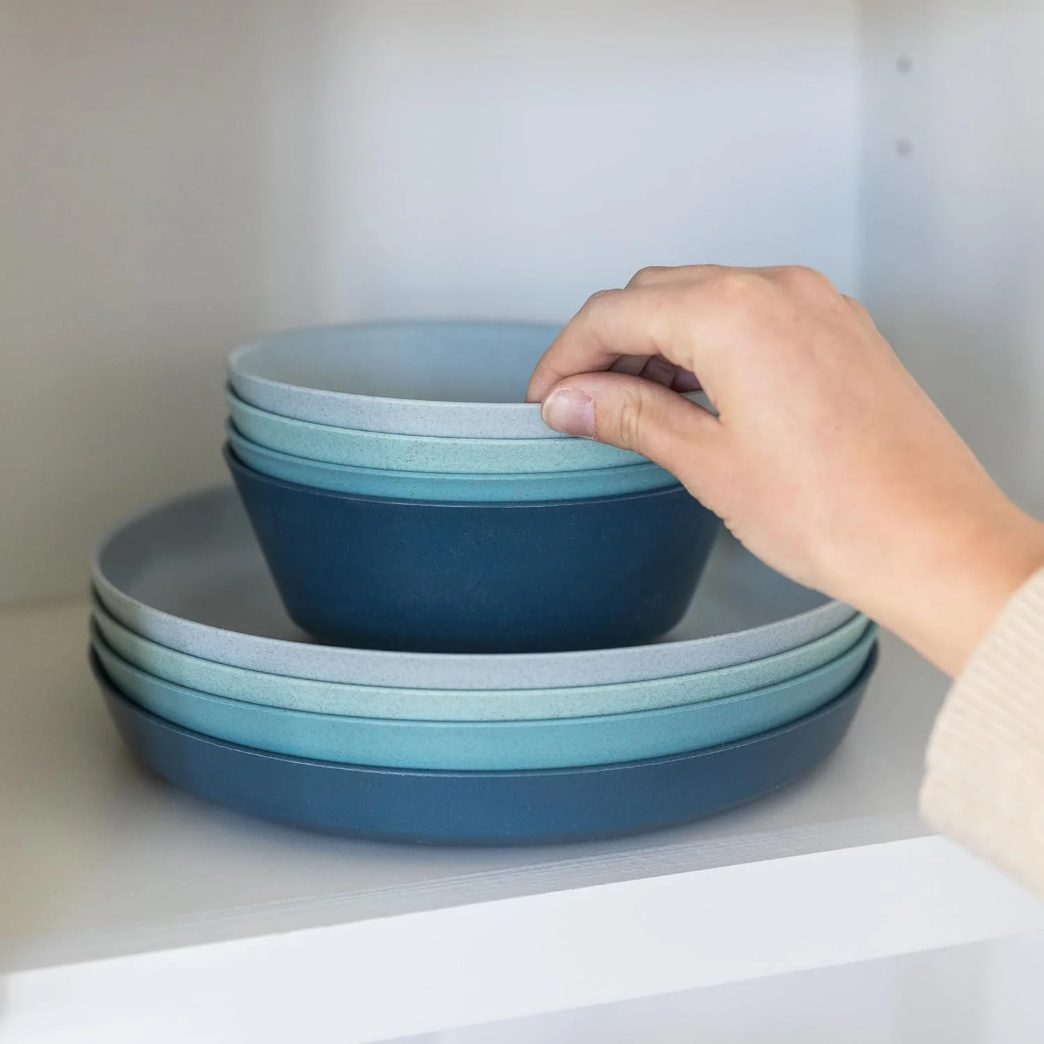 Two-color plate and bowl stacking detail Four bowls and four plates stacked in alternating light and deep blue tones for nesting review